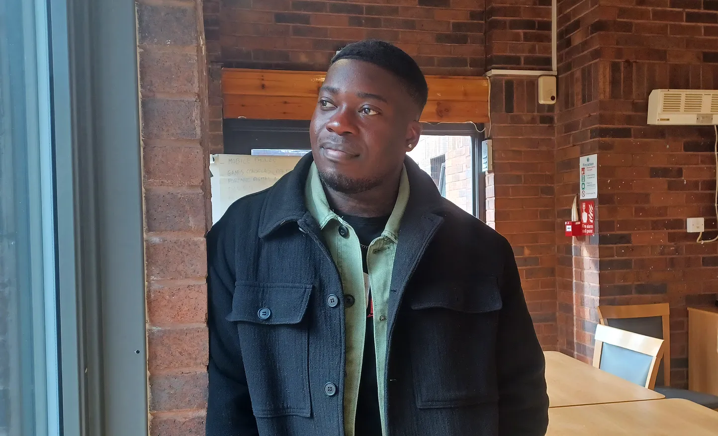 Christian, a young black male against a brick backdrop