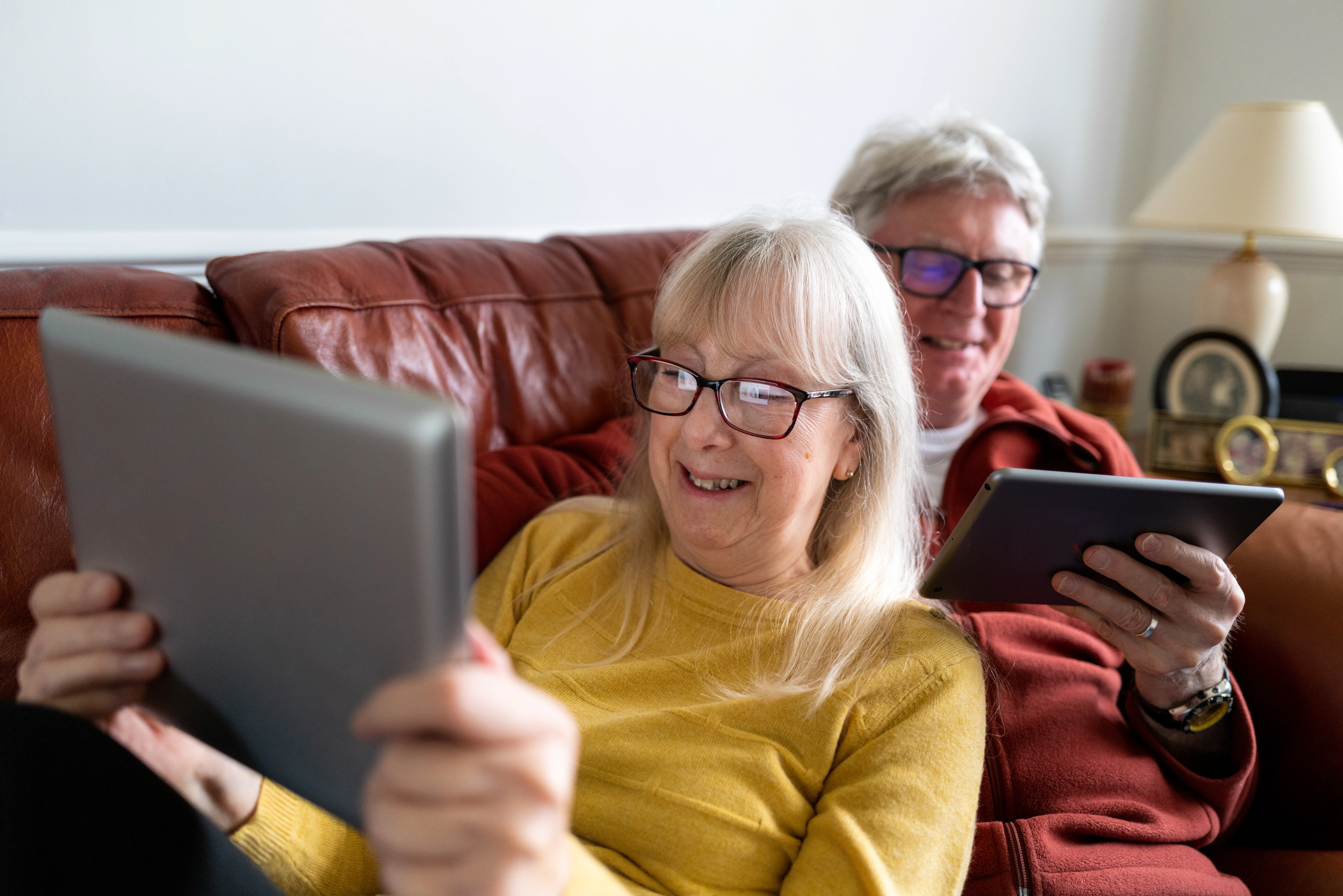 two elderly people with ipads