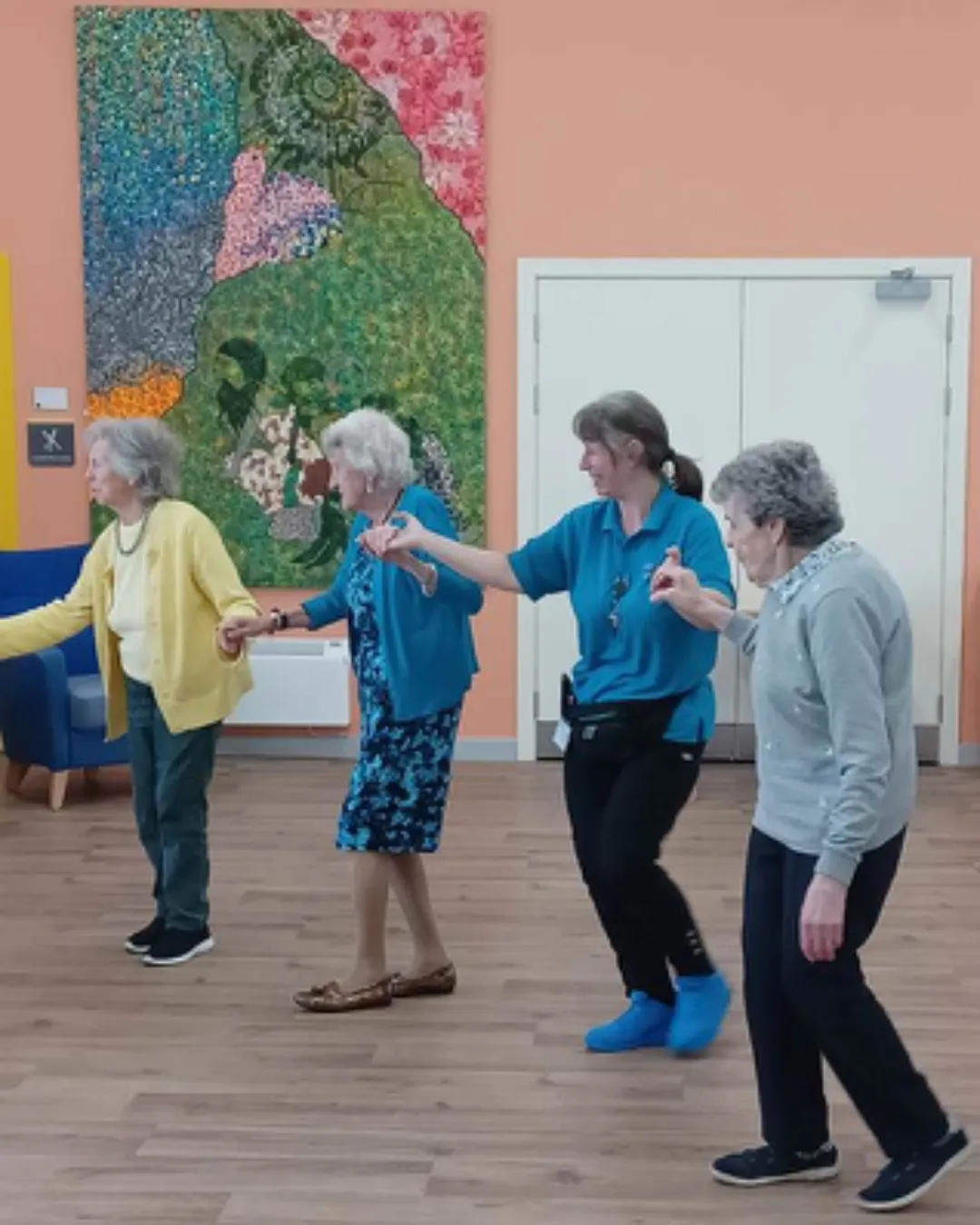 elderly ladies and a carer dancing