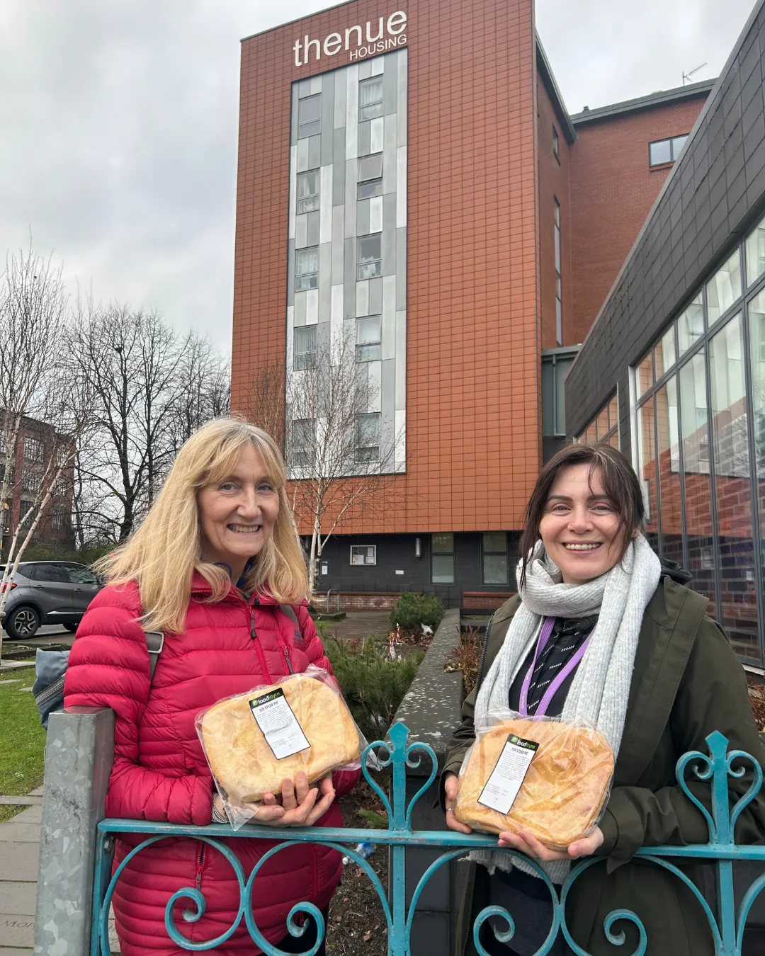 two women with food parcels outside thenue housing association